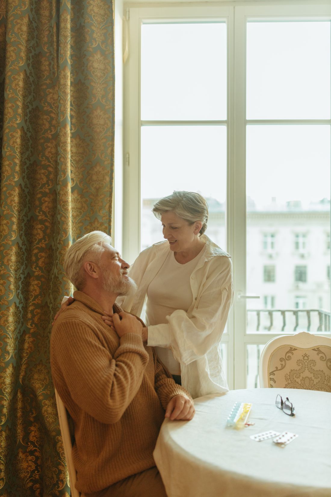 A caregiver and a senior sharing a quiet, restful moment beside a sunlit window